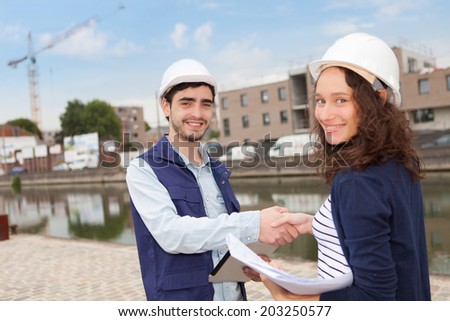 Architect woman and construction site supervisor shaking hands