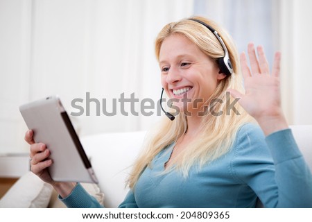 VIew of a Young attractive woman blonde chatting on tablet
