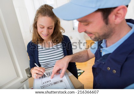 View of a Young attractive woman signing on delivery paper