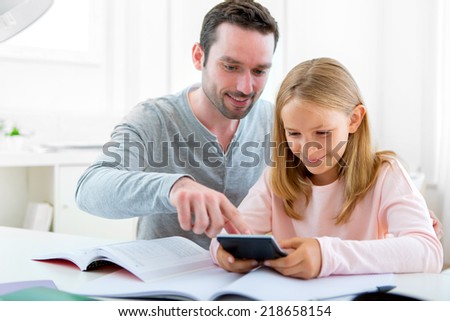 View of a Father helping out her daughter for homework