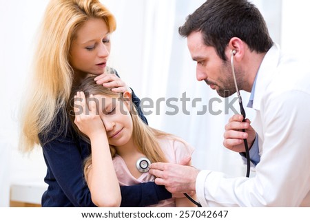View of a Doctor listening heart beatment of little girl