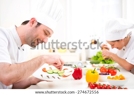 View of a Young attractive professional chef cooking in his kitchen