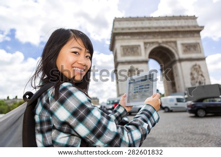 View of a Young attractive asian tourist using tablet in Paris