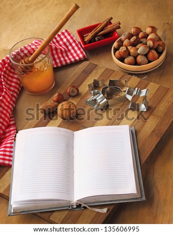 Opened book for the records of recipes and honey  nuts, cinnamon, forms for a thin captain  on a cook-table
