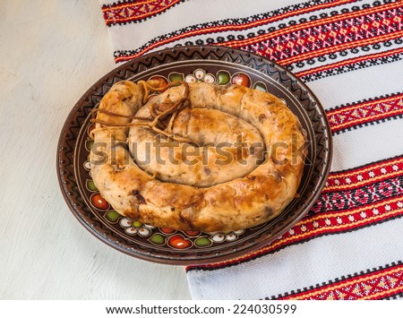 Home fried sausage on a plate and an embroidered tablecloth with Ukrainian folk pattern