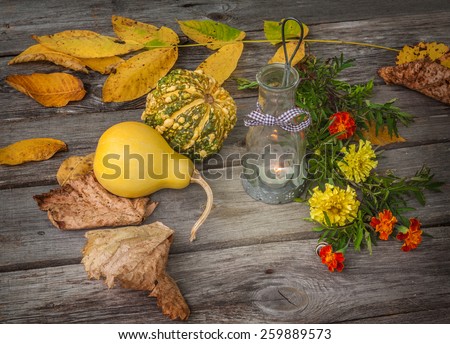 Burning lamp, pumpkins and leaves on a wooden table