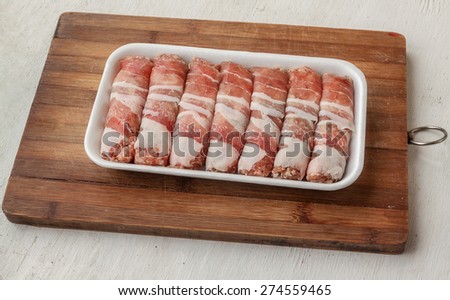 Raw meat loafs and piece of meat  on the cutting board on the kitchen table