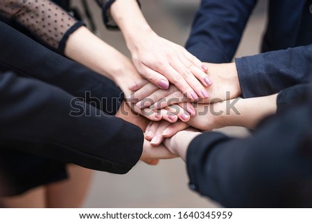 close up top view of workers putting hands together piling on top of one another representing teamwork, community help and support within the small business or company within an office environment Stock foto © 