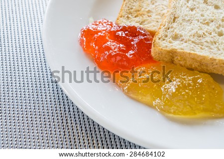 Bread, butter and jam, orange marmalade, strawberry and berry.