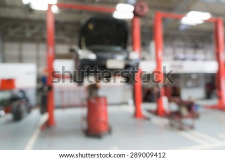 Blurred of car technician repairing the car in garage background.