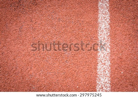 Red running tracks in sport stadium background.