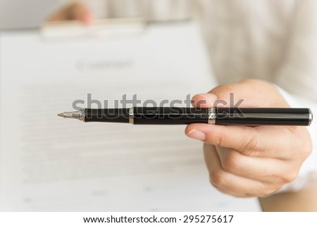 Businessman handing  a contract attached  for signature  and pen in his hand. selective focus.