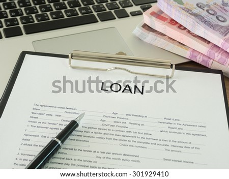 The loans documents and banknotes on desk\'s bankers.