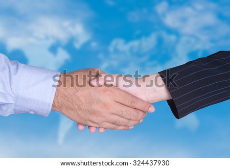 partners business handshake with blurred world map background.