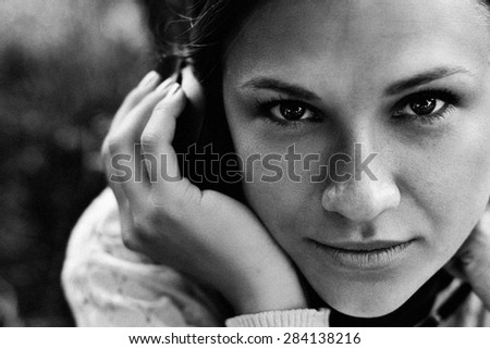 Beautiful girl in a park listening to the sound of music in the headphones (black and white, soft focus)
