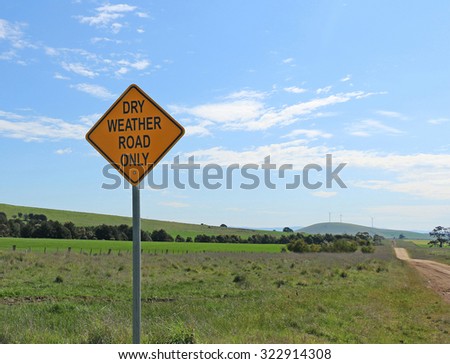 black and yellow dry weather road only sign