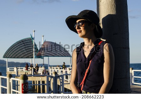 Beautiful young woman wearing sleeveless shirt in afternoon light, Townsville, Queensland, Australia
