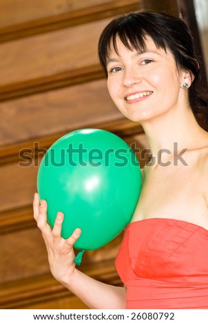 Party Girl on Stairs Attractive young woman in red dress with green balloon on stairs
