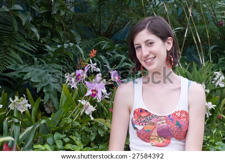 Attractive girl with orchids and lush foliage
