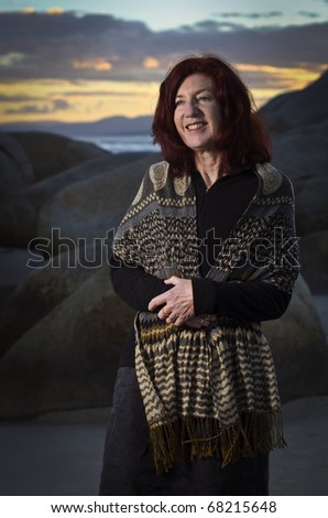 Attractive mature woman at beach with dramatic lighting