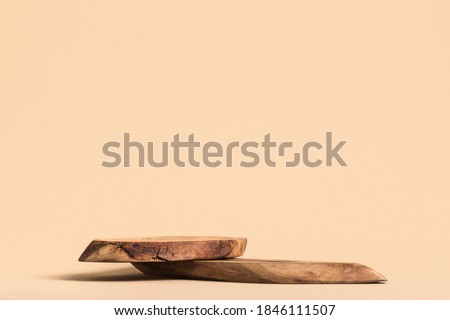 Rustic wood pieces podium. Background for perfume and cosmetic products on beige color.  Front view.