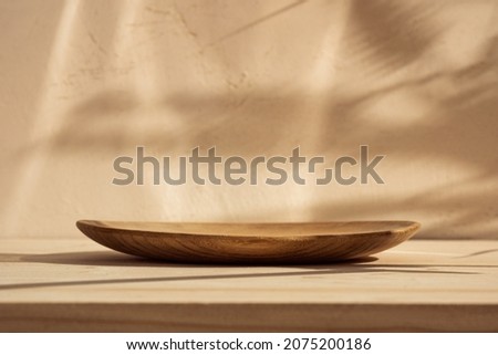 Round wooden podium for food, products or cosmetics against bright brown background with natural sun shadows. Front view.
 Stock foto © 