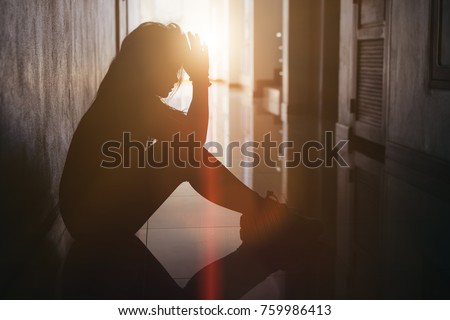 Silhouette of sad and depressed women sitting at walkway of condominium or office with backlit and lens flare,sad mood,feel tired, lonely and unhappy. Foto d'archivio © 