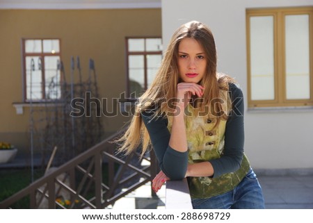 beautiful young girl on the background buildings in casual clothes and no makeup