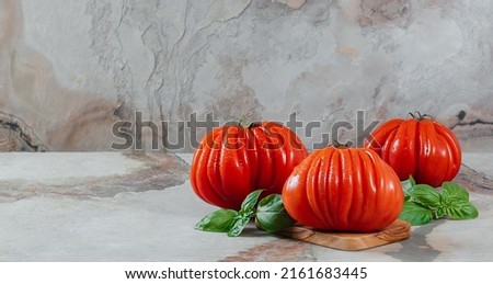 Fresh Raf Coeur De Boeuf tomatoes and basil on a brown background, space for text, restaurant concept, stock photo Zdjęcia stock © 