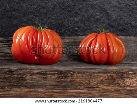 Two Raf Coeur De Boeuf tomatoes on a wooden background, rustic concept, stock photo Zdjęcia stock © 