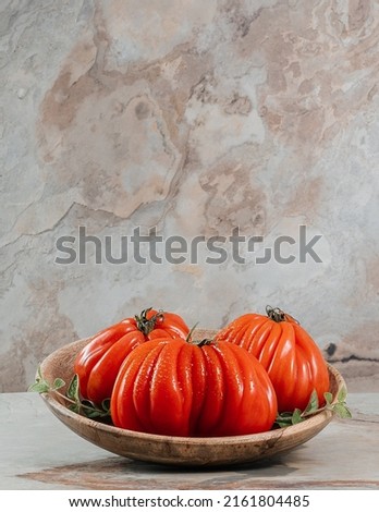 Three fresh Raf Coeur De Boeuf tomatoes and oregano on a wooden plate, brown background, rustic concept, space for text, stock photo Zdjęcia stock © 