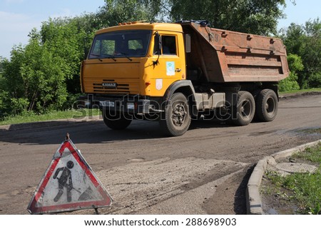 NABEREZHNYE CHELNY - JUNE 1, 2015: Road repairing on Gabdully Tukaya embankment. Truck at work. Sigh \'Construction zone\'.