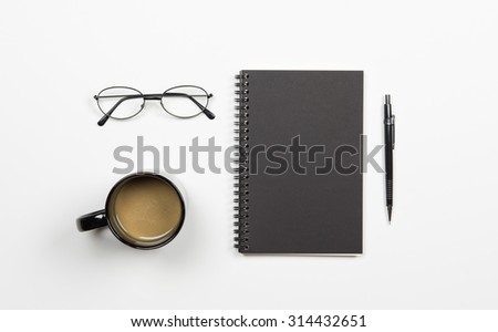 iron glasses,coffee in black cup,black notepad cover,black pencil with white background.