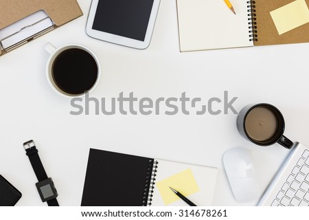 meeting office desk from top view , black and white coffee mug,black watch,mouse,keyboard,black and brown notepad, yellow post it note,folder,tablet ,yellow pencil with white background / meeting room