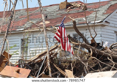 A US American flag rises above a home ruined by a deadly EF-5 tornado.