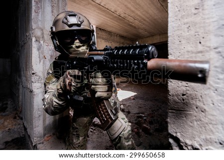 Portrait of armed soldier in mask and helmet during the military operation in a buiding/Armed soldier during the military operation in a buiding