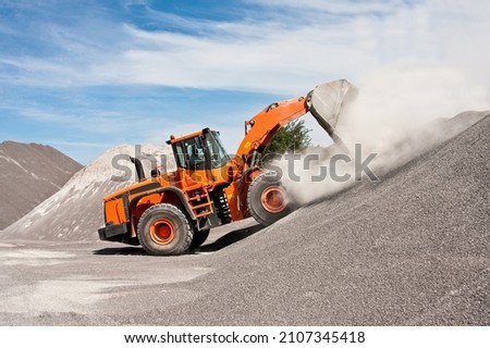 the orange loader is loading the aggregate Foto stock © 