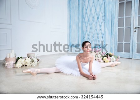 Young a beautiful ballerina is dancing in the studio