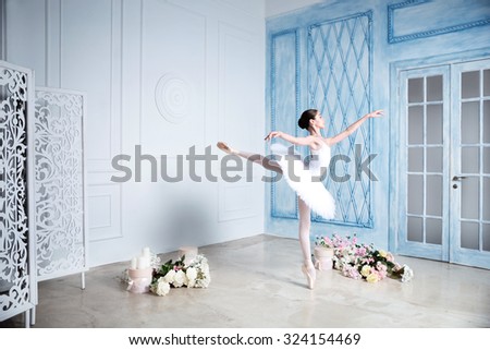 Young a beautiful ballerina is dancing in the studio