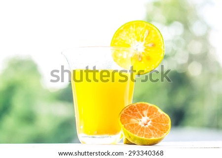 orange juice and soft light back ground and strong sunlight at noon