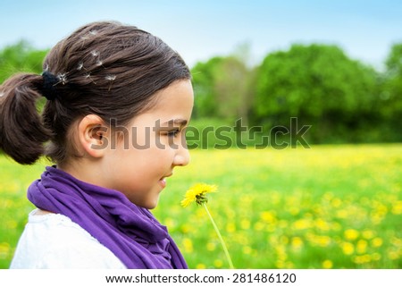 Beautiful girl with Dandelion flowers outdoor. Child playing outdoors. Girl is happy outside and having fun.