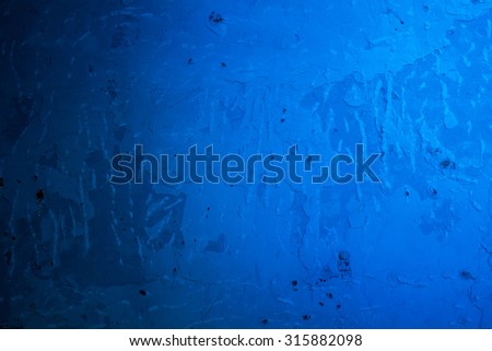 Cement wall with blue light with dark shadow.