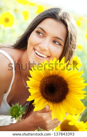 Close-up portrait of beautiful joyful woman with sunflower