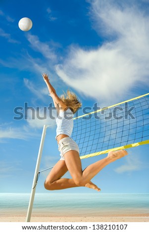 Jump up of sports young woman playing volleyball on sea beach