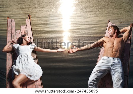 Romantic couple in love against sea water with sunlight reflection
