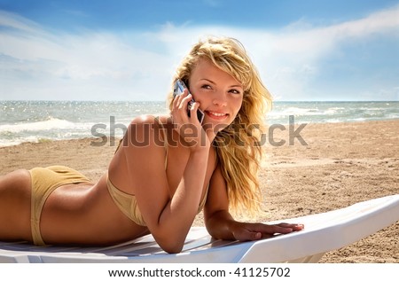 Landscape with  the beautiful happy girl, talking  on phone on a  sea coast