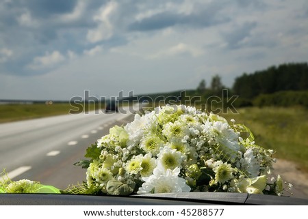 Car view from the window on a beautiful wedding flower bouquet and highway