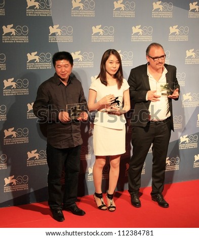 VENICE - SEPTEMBER 8: Wang Bing, Yoo Min-young and Frederic Fonteyne pose for photographers at 69th Venice Film Festival on September 8, 2012 in Venice, Italy.
