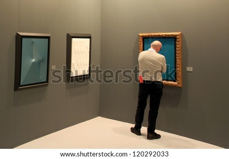 MILAN - APRIL 08: A man looking at paintings galleries during MiArt, international exhibition of modern and contemporary art on April 08, 2011 in Milan, Italy