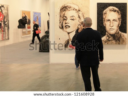 MILAN - APRIL 08: A man looks at paintings during MiArt, international exhibition of modern and contemporary art on April 08, 2011 in Milan, Italy